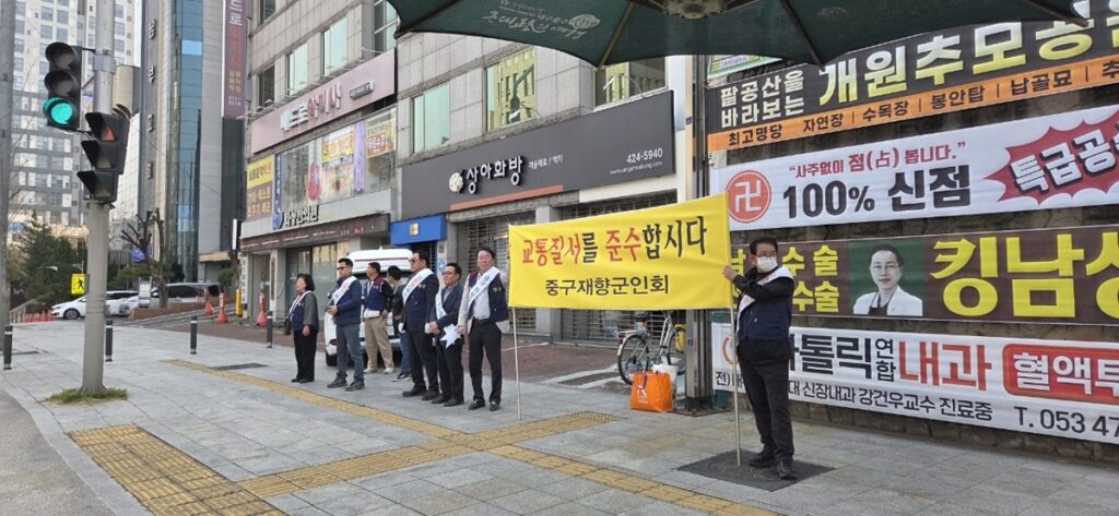 중구 시내 교차로 인근에서 회원들이 현수막을 펼치고 출근길 운전자들에게 교통안전을 홍보하는 전경