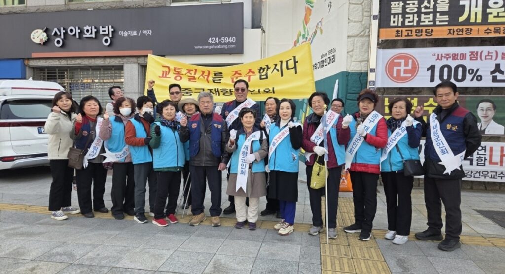 '교통질서를 준수합시다' 현수막을 든 대구 중구 재향군인회 회원들의 단체 기념 촬영 모습