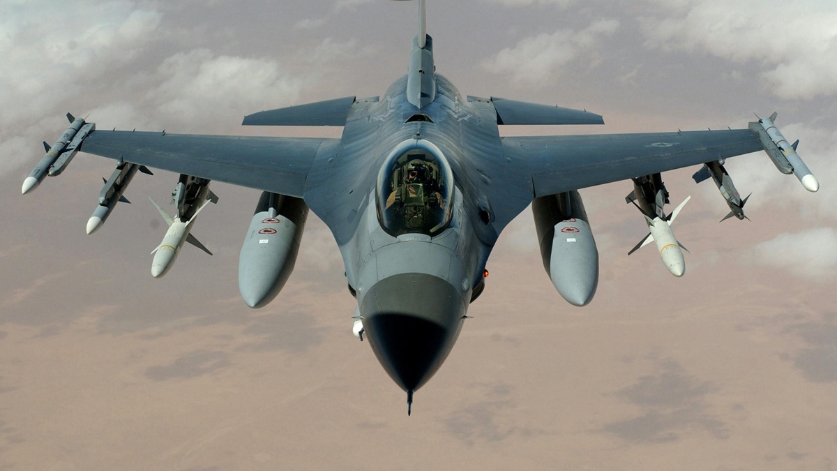 사막 지역 위를 비행 중인 미 공군 F-16 전투기의 정면 모습. 날개 하단에 보조 연료탱크와 미사일 등 무장을 장착하고 있는 전투기와 중동 지역 정밀 타격 및 군사적 긴장 고조 관련 안보 보도 이미지 (출처: Wikimedia Commons)