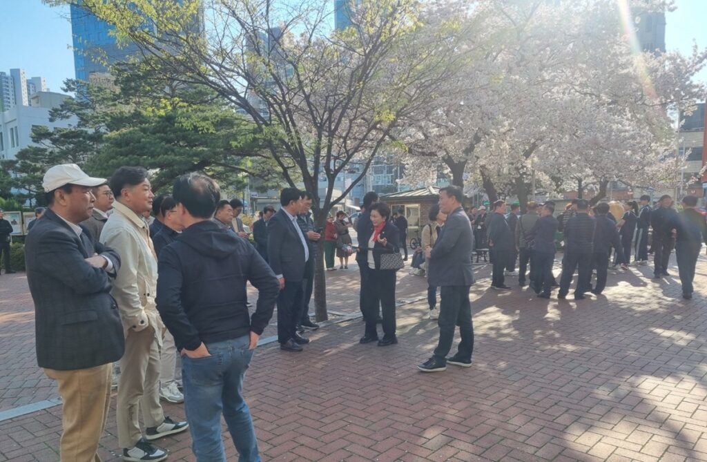벚꽃 아래 모여 대화 중인 시민들과 지지자들