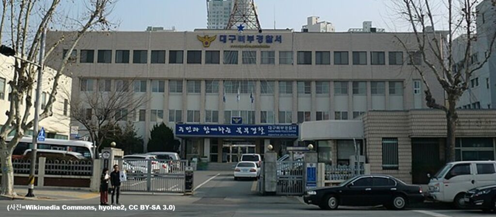 대구광역시 북구에 위치한 대구 북부경찰서 본관 건물의 외경과 여행용 가방 시신 유기 사건의 딸 부부 긴급 체포 및 수사 관련 지역 사회 보도 이미지 (출처: Wikimedia Commons)