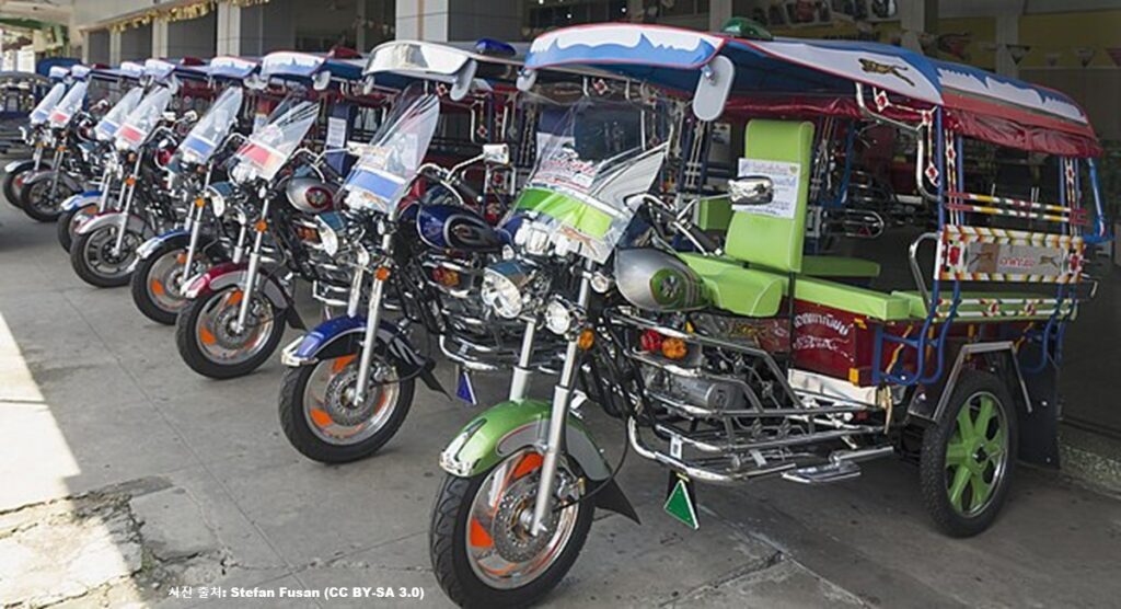 파키스탄 거리의 주차장에 일렬로 늘어선 화려한 장식의 삼륜차 툭툭(Tuk-tuk)