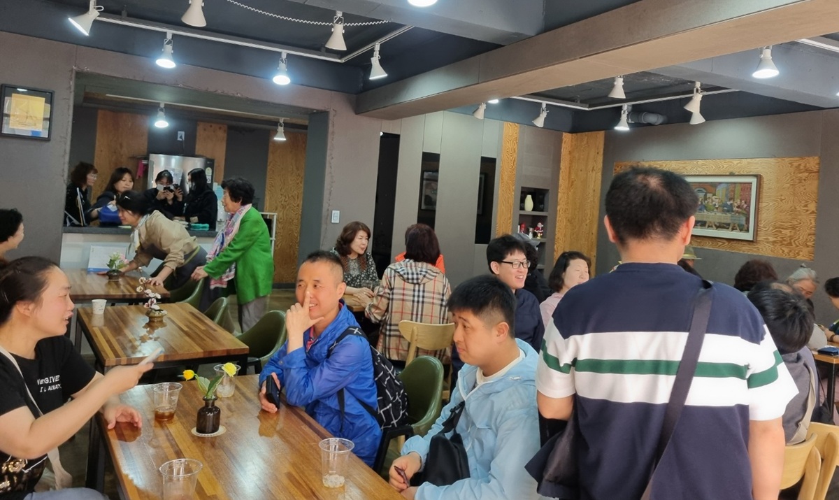 교회 카페에서 주민들이 차를 마시며 대화하는 모습