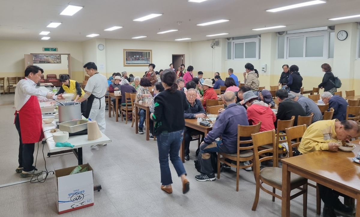 어르신들이 함께 식사하는 모습, 지역 무료 급식 행사 분위기