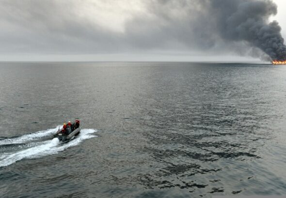U.S._Sailors_assigned_to_the_guided_missile_destroyer_USS_William_P._Lawrence_(DDG_110)_survey_the_area_surrounding_a_burning_vessel_for_possible_survivors_March_11,_2013,_while_transiting_the_S